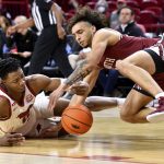 
              Arkansas guard Stanley Umude, left, and South Carolina guard Devin Carter scramble for the ball during the first half of an NCAA college basketball game Tuesday, Jan. 18, 2022, in Fayetteville, Ark. (AP Photo/Michael Woods)
            