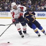 
              Washington Capitals center Nic Dowd (26) reaches for the puck as St. Louis Blues left wing Brandon Saad (20) defends during the second period of an NHL hockey game Friday, Jan. 7, 2022, in St. Louis. (AP Photo/Joe Puetz)
            