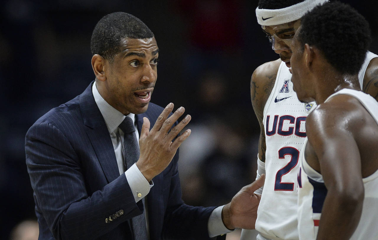 FILE - Connecticut head coach Kevin Ollie, left, talks with Connecticut's Terry Larrier and Christi...