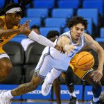 
              UCLA guard Jules Bernard, right, dives in an attempt to reach the ball next to Long Beach State guard Colin Slater during the second half of an NCAA college basketball game Thursday, Jan. 6, 2022, in Los Angeles. UCLA won 96-78. (AP Photo/Ringo H.W. Chiu)
            