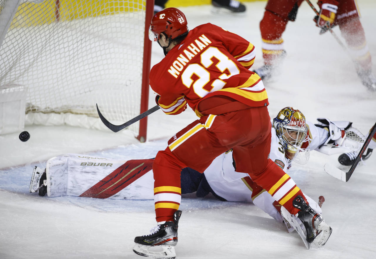 Florida Panthers goalie Spencer Knight watches as Calgary Flames' Sean Monahan scores during the th...