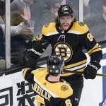 
              Boston Bruins right wing David Pastrnak smiles as he is congratulated by defenseman Mike Reilly (6) after his goal against the Anaheim Ducks during the second period of an NHL hockey game, Monday, Jan. 24, 2022, in Boston. (AP Photo/Charles Krupa)
            