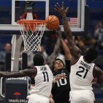 
              Connecticut's Akok Akok (11) and Adama Sanogo (21) stop a shot attempt by Butler's Bryce Nze (10) during the first half of an NCAA college basketball game Tuesday, Jan. 18, 2022, in Hartford, Conn. (AP Photo/Jessica Hill)
            