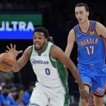 
              Dallas Mavericks forward Sterling Brown (0) drives up the court in front of Oklahoma City Thunder center Aleksej Pokusevski (17) in the first half of an NBA basketball game Sunday, Jan. 2, 2022, in Oklahoma City. (AP Photo/Sue Ogrocki)
            