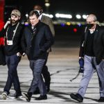 
              Georgia coach Kirby Smart, center, walks after the team arrived at Indianapolis International Airport on Friday, Jan. 7, 2022, in Indianapolis. Georgia is scheduled to play Alabama in the College Football Playoff championship game Monday. (Michelle Pemberton/The Indianapolis Star via AP)
            