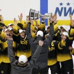 
              FILE - Boston Pride players cheer as coach Paul Mara hoists the NWHL Isobel Cup trophy after the team's win over the Minnesota Whitecaps in the championship hockey game in Boston, Saturday, March 27, 2021. The Premier Hockey Federation is more than doubling each teams’ salary cap to $750,000 and adding two expansion franchises next season in a bid to capitalize on the wave of attention women’s hockey traditionally enjoys following the Winter Olympics. (AP Photo/Mary Schwalm, File)
            