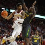 
              Iowa State guard Tyrese Hunter (11) passes under the basket as Baylor forward Jonathan Tchamwa Tchatchoua (23) defends during the first half of an NCAA college basketball game, Saturday, Jan. 1, 2022, in Ames. (AP Photo/Matthew Putney)
            