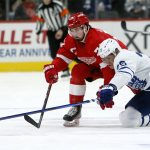 
              Toronto Maple Leafs right wing Ondrej Kase (25) knocks the puck away from Detroit Red Wings center Dylan Larkin (71) during the first period of an NHL hockey game Saturday, Jan. 29, 2022, in Detroit. (AP Photo/Duane Burleson)
            