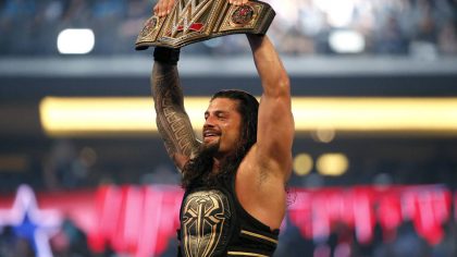 FILE - Roman Reigns holds up the championship belt after defeating Triple H during WrestleMania 32 ...