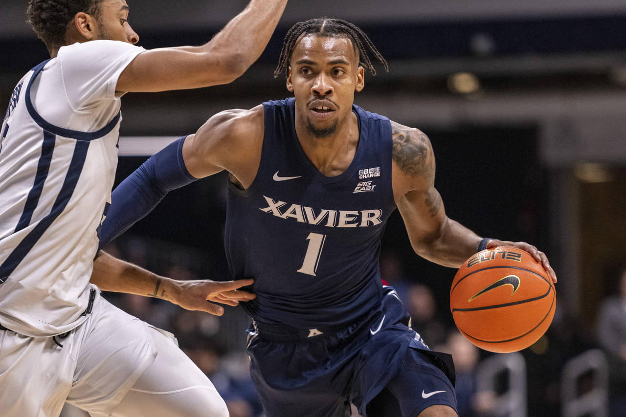 Xavier guard Paul Scruggs (1) drives against Butler guard Aaron Thompson during the first half of a...