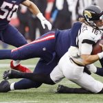 
              Jacksonville Jaguars quarterback Trevor Lawrence (16) is sacked by New England Patriots defensive end Christian Barmore, rear, during the first half of an NFL football game, Sunday, Jan. 2, 2022, in Foxborough, Mass. (AP Photo/Paul Connors)
            