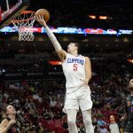 
              Los Angeles Clippers guard Luke Kennard (5) goes to the basket over Miami Heat guard Duncan Robinson, left, and forward P.J. Tucker (17) during the second half of an NBA basketball game, Friday, Jan. 28, 2022, in Miami. (AP Photo/Lynne Sladky)
            
