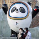 
              People wearing face masks to protect against coronavirus walk past a statue of the Winter Olympic mascot Bing Dwen Dwen near the Olympic Green in Beijing, Wednesday, Jan. 12, 2022. Just weeks before hosting the Beijing Winter Olympics, China is battling multiple coronavirus outbreaks in half a dozen cities, with the one closest to the capital driven by the highly transmissible omicron variant. (AP Photo/Mark Schiefelbein)
            