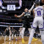 
              Milwaukee Bucks guard Donte DiVincenzo (0) defends against a pass by Sacramento Kings guard Tyrese Haliburton (0) during the first half of an NBA basketball game Saturday, Jan. 22, 2022, in Milwaukee. (AP Photo/Jon Durr)
            