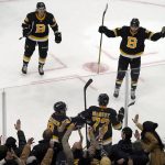 
              Boston Bruins defenseman Charlie McAvoy (73) is congratulated by teammates at the glass as fans cheer after he scored the winning goal past Washington Capitals goaltender Vitek Vanecek late in the third period of an NHL hockey game, Thursday, Jan. 20, 2022, in Boston. (AP Photo/Mary Schwalm)
            