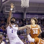 
              TCU guard Mike Miles (1) scores against Texas forward Christian Bishop (32) and Courtney Ramey (3) during the first half of an NCAA college basketball game in Fort Worth, Texas, Tuesday, Jan. 25, 2022. (AP Photo/Gareth Patterson)
            