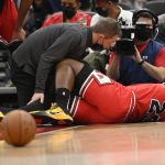 
              Chicago Bulls forward Tyler Cook (25) is tended to after he was injured during the first half of an NBA basketball game against the Washington Wizards, Saturday, Jan. 1, 2022, in Washington. (AP Photo/Nick Wass)
            