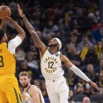 
              Indiana Pacers forward Oshae Brissett (12) attempts to block a shot by Utah Jazz forward Rudy Gay (8) during the first half of an NBA basketball game in Indianapolis, Saturday, Jan. 8, 2022. (AP Photo/Doug McSchooler)
            