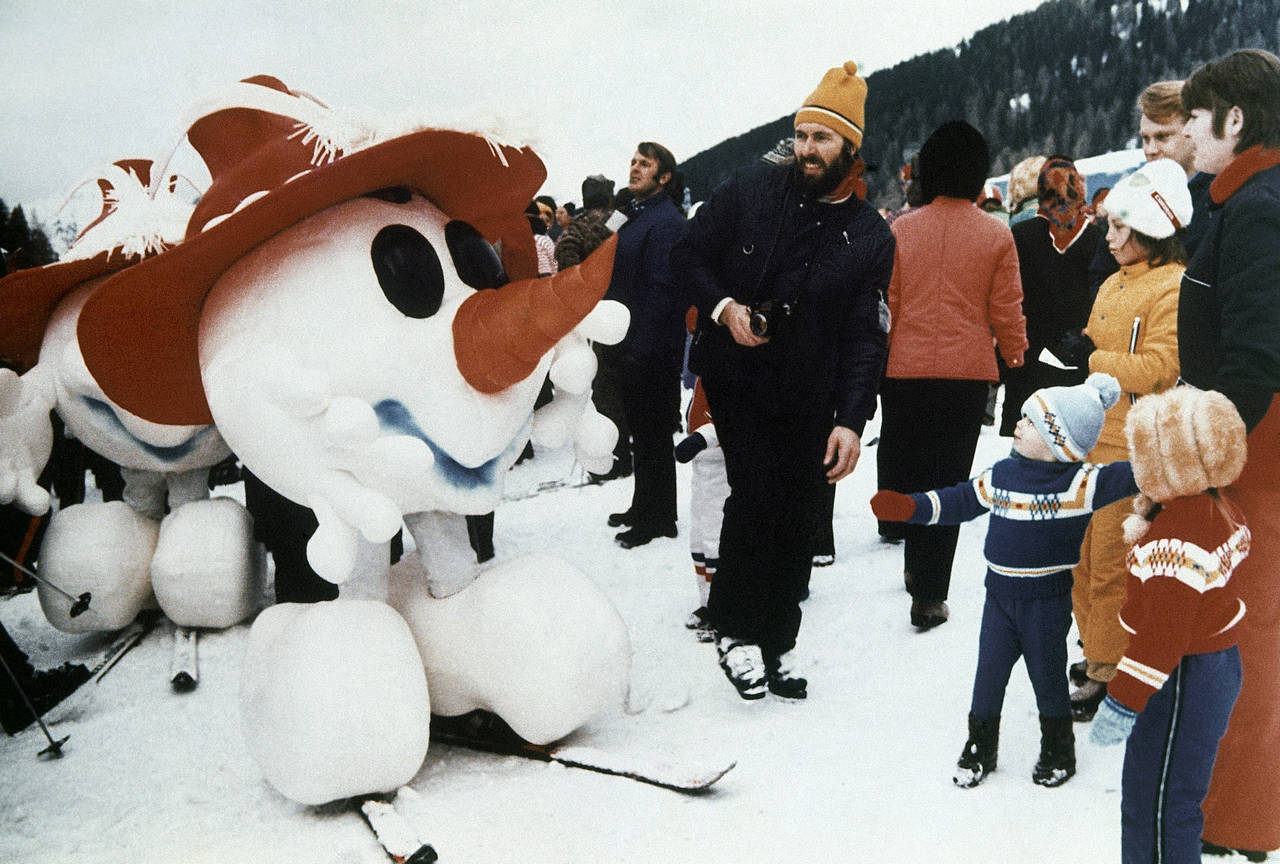 A snowman, mascot of the 1976 Winter Olympics in Innsbruck, greets children in Kitzbuhel, Austria, ...