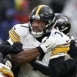 
              Pittsburgh Steelers quarterback Ben Roethlisberger, center, is sandwiched between Baltimore Ravens nose tackle Justin Ellis, left, and inside linebacker Patrick Queen, right, during the first half of an NFL football game, Sunday, Jan. 9, 2022, in Baltimore. (AP Photo/Evan Vucci)
            