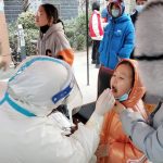
              A medical worker wearing a protective suit swabs a child for a coronavirus test in Huaxian County in central China's Henan Province, Friday, Jan. 14, 2022. China further tightened its anti-pandemic measures in Beijing and across the country on Friday as scattered outbreaks continued ahead of the opening of the Winter Olympics in a little over two weeks. (Chinatopix via AP)
            
