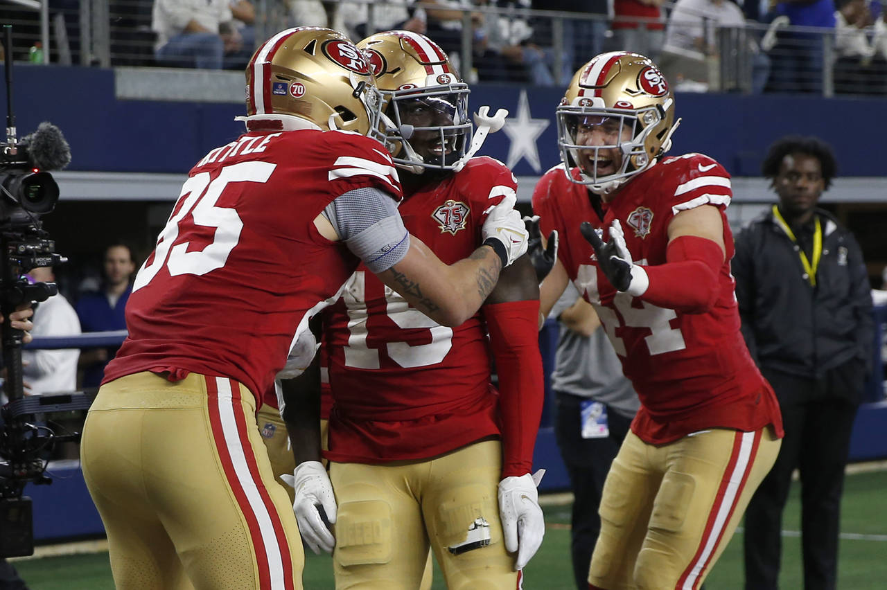 San Francisco 49ers wide receiver Deebo Samuel, middle, is congratulated by tight end George Kittle...