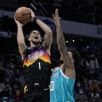 
              Phoenix Suns guard Devin Booker shoots over Charlotte Hornets forward Miles Bridges during the first half of an NBA basketball game on Sunday, Jan. 2, 2022, in Charlotte, N.C. (AP Photo/Chris Carlson)
            