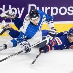 
              United States' Matty Beniers (10) and Finland's Kasper Puutio (10) battle for the puck during first period of an exhibition game in Edmonton, Alberta, Thursday, Dec. 23, 2021, before the IIHF World Junior Hockey Championship tournament. (Jason Franson/The Canadian Press via AP)
            