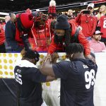 
              Georgia defensive tackle Jordan Davis, bottom right, prays with his mother Shay Allen, top right, before playing Alabama in the College Football Playoff championship game Monday, Jan. 10, 2022, in Indianapolis. (Curtis Compton/Atlanta Journal-Constitution via AP)
            
