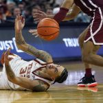 
              Texas forward Christian Bishop (32) dives past Oklahoma guard Jordan Goldwire, right, for a loose ball during the second half of an NCAA college basketball game, Tuesday, Jan. 11, 2022, in Austin, Texas. (AP Photo/Eric Gay)
            