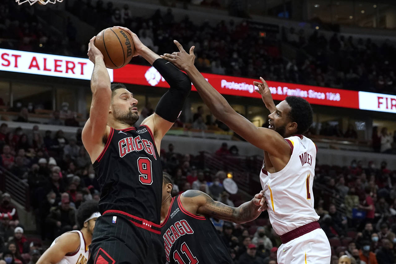 Chicago Bulls' Nikola Vucevic (9) grabs a defensive rebound as Cleveland Cavaliers' Evan Mobley def...