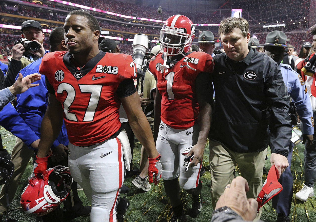 FILE - Georgia's Nick Chubb, from left, Sony Michel and Kirby Smart walk off the field as Georgia l...