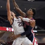 
              Texas A&M guard Andre Gordon (20) is fouled by Mississippi forward Luis Rodriguez (15) on a fast break layup during the second half of an NCAA college basketball game Tuesday, Jan. 11, 2022, in College Station, Texas. (AP Photo/Sam Craft)
            