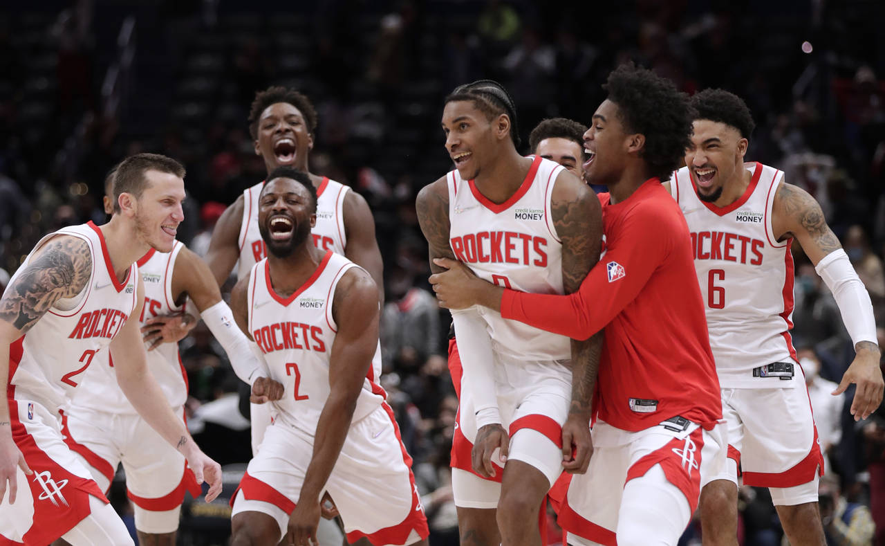 Houston Rockets' Kevin Porter Jr., front second from right in front, celebrates with his teammates ...