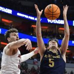 
              Notre Dame guard Cormac Ryan (5) tries to grab a rebound over Louisville forward Matt Cross (33) during the first half of an NCAA college basketball game in Louisville, Ky., Saturday, Jan. 22, 2022. (AP Photo/Timothy D. Easley)
            