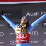 
              Italy's Sofia Goggia celebrates on the podium after winning the alpine ski, women's World Cup downhill, in Cortina d'Ampezzo, Italy, Saturday, Jan. 22, 2022. (AP Photo/Alessandro Trovati)
            