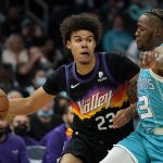 
              Phoenix Suns forward Cameron Johnson drives to the basket past Charlotte Hornets guard Terry Rozier during the first half of an NBA basketball game on Sunday, Jan. 2, 2022, in Charlotte, N.C. (AP Photo/Chris Carlson)
            
