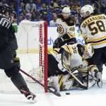 
              Boston Bruins goaltender Linus Ullmark (35) makes a save on a shot by Tampa Bay Lightning right wing Corey Perry (10) during the second period of an NHL hockey game Saturday, Jan. 8, 2022, in Tampa, Fla. Defending for the Bruins is Urho Vaakanainen (58). (AP Photo/Chris O'Meara)
            