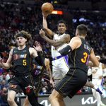 
              Los Angeles Lakers guard Malik Monk, center, looks to pass as Miami Heat guards Kyle Guy (5) and Max Strus (31) defend during the first half of an NBA basketball game, Sunday, Jan. 23, 2022, in Miami. (AP Photo/Lynne Sladky)
            