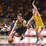 
              Baylor guard Matthew Mayer (24) drives to the net while being guarded by West Virginia guard Sean McNeil (22) during the second half of an NCAA college basketball game in Morgantown, W.Va., Tuesday, Jan. 18, 2022. (William Wotring)
            