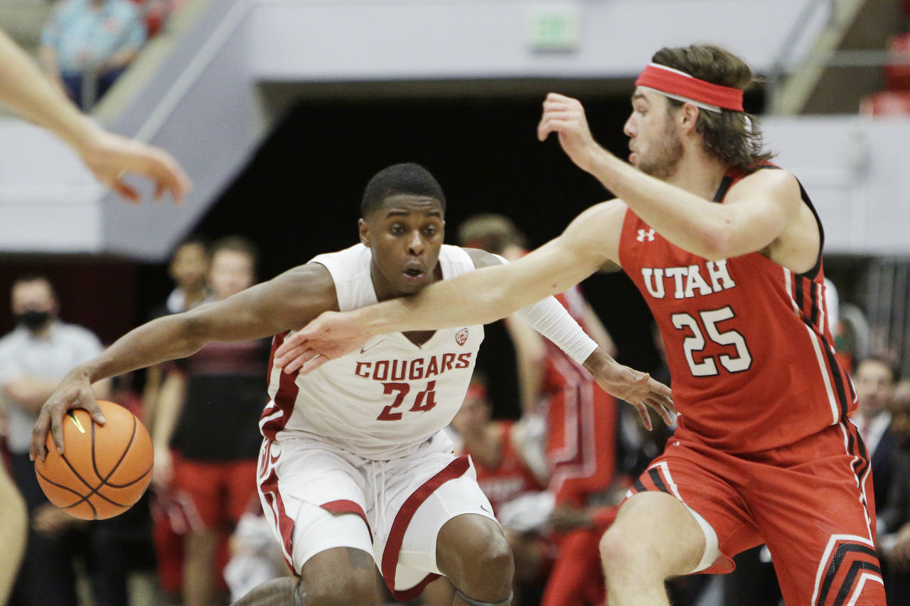 Washington State guard Noah Williams (24) drives the ball while pressured by Utah guard Rollie Wors...