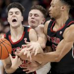 
              Arizona guard Pelle Larsson, center, is squeezed between Utah guards Lazar Stefanovic, left, and Marco Anthony, right, while fighting through a pick in the first half of an NCAA college basketball game in Tucson, Ariz., Saturday, Jan. 15, 2022. (Kelly Presnell/Arizona Daily Star via AP)
            