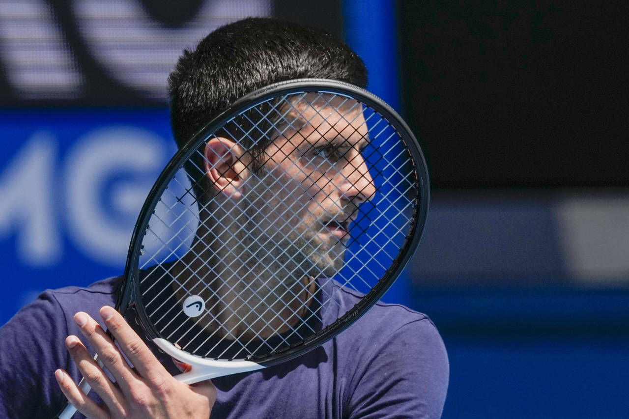 FILE - Defending champion Serbia's Novak Djokovic practices ahead of the Australian Open tennis cha...