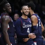 
              Connecticut guard Tyrese Martin, center, is congratulated by teammates Tyler Polley, right, and Adama Sanogo after being fouled in the second half of an NCAA college basketball game against Butler in Indianapolis, Thursday, Jan. 20, 2022. (AP Photo/AJ Mast)
            