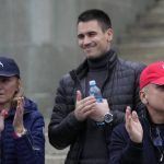 
              Serbia's Novak Djokovic's father Srdjan, right, brother Djordje, center, and mother Dijana applaud during a protest in Belgrade, Serbia, Thursday, Jan. 6, 2022. The Australian government has denied No. 1-ranked Novak Djokovic entry to defend his title in the year's first tennis major and canceled his visa because he failed to meet the requirements for an exemption to the country's COVID-19 vaccination rules. (AP Photo/Darko Vojinovic)
            