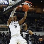 
              Providence's Ed Croswell (5) slam dunks past the defense of Georgetown's Donald Carey (13) during the first half of an NCAA college basketball game Thursday, Jan. 20, 2022, in Providence, R.I. (AP Photo/Stew Milne)
            