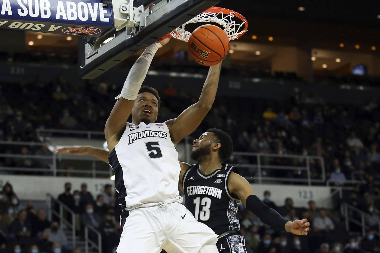 Providence's Ed Croswell (5) slam dunks past the defense of Georgetown's Donald Carey (13) during t...