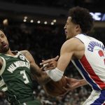 
              Detroit Pistons' Cade Cunningham (2) commits an offensive foul against Milwaukee Bucks' George Hill (3) during the first half of an NBA basketball game Monday, Jan. 3, 2022, in Milwaukee. (AP Photo/Aaron Gash)
            