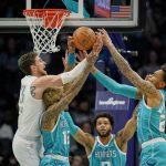 
              Oklahoma City Thunder center Mike Muscala, left, vies for ra ebound with Charlotte Hornets guard Kelly Oubre Jr. (12) and forward P.J. Washington, right, as Hornets forward Miles Bridges watches during the first half of an NBA basketball game Friday, Jan. 21, 2022, in Charlotte, N.C. (AP Photo/Rusty Jones)
            