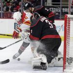 
              Calgary Flames center Blake Coleman, left, fights for the puck against Carolina Hurricanes defenseman Brett Pesce, top center, and goaltender Frederik Andersen (31) during the first period of an NHL hockey game Friday, Jan. 7, 2022, in Raleigh, N.C. (AP Photo/Chris Seward)
            
